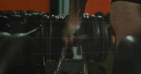 Hand grasping dumbbell in gym for strength training