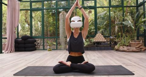 Woman Practicing Yoga with VR Headset in Serene Environment