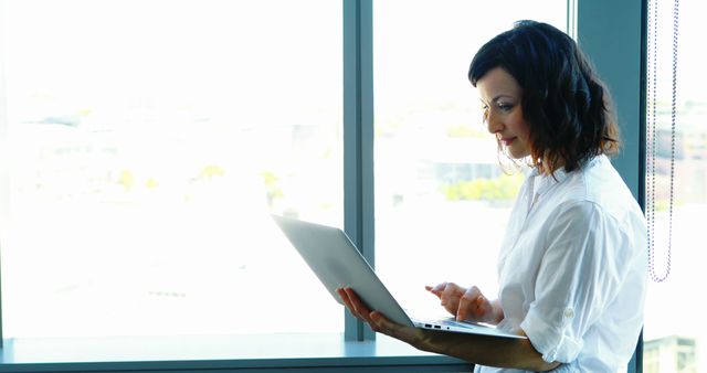 Professional Woman Working on Laptop in Bright Office Space - Download Free Stock Images Pikwizard.com