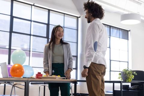 Colleagues Celebrating Office Event with Balloons and Cake