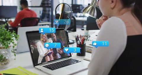 Remote video call with social media notifications on laptop in modern coworking office