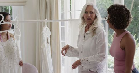 Friends choosing wedding dress at bridal boutique