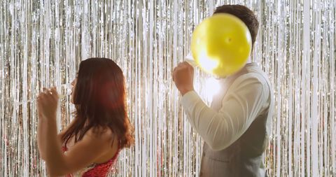 Couple celebrating at festive party with balloons