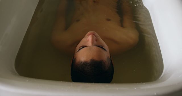 Depicts man enjoying relaxing bath, perfect for content related to self-care, wellness, personal relaxation, and mental health awareness.