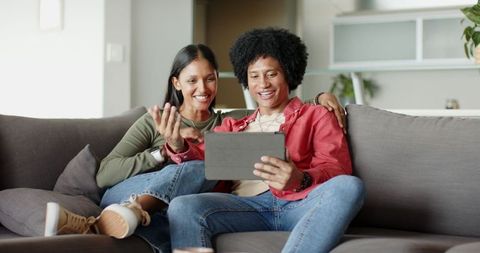 Diverse Couple Using Tablet to Connect in Modern Living Room