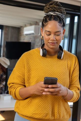 Modern Professional Woman Engaging with Smartphone in Office