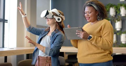 Diverse women conducting virtual reality demo in modern coworking office environment