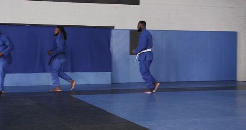 Karate students training in dojo wearing blue martial arts uniforms