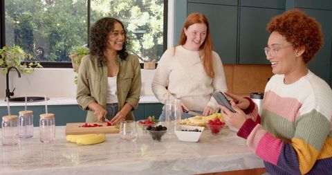 Diverse Female Friends Making Smoothies Together in Modern Kitchen