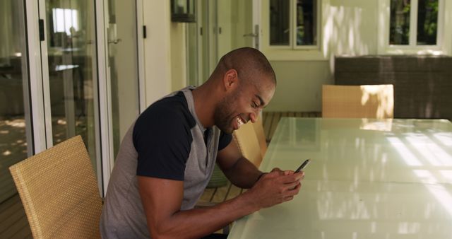 Man Smiling While Texting On Smartphone Sitting At Outdoor Table - Download Free Stock Images Pikwizard.com