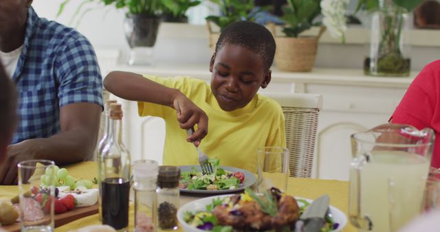 Young Boy Enjoying Meal with Family at Dining Table - Download Free Stock Images Pikwizard.com