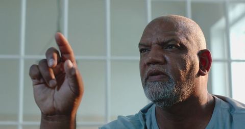 Elderly man reflecting thoughtfully in bright room