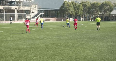 Youth soccer match on sunny neighborhood field