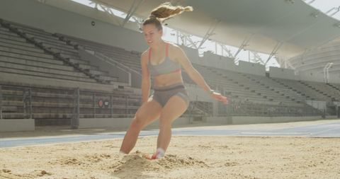 Female athlete practicing long jump in sports stadium