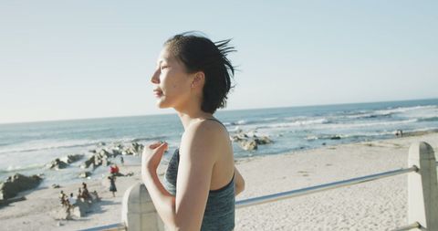 Asian Woman Running on Beach at Sunset Promoting Healthy Lifestyle