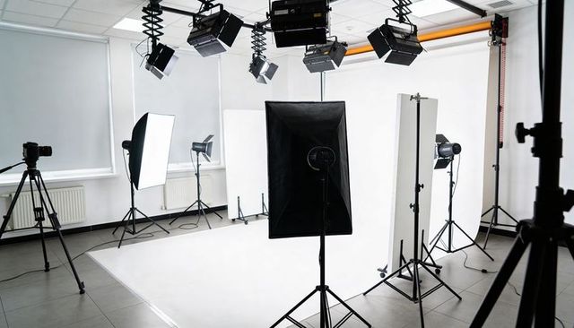 Studio softbox lighting illuminating seamless white backdrop with reflectors and tripods