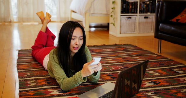Woman using mobile phone in living room at home