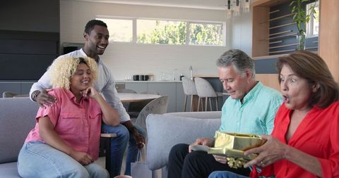 Senior Couple Celebrating Pregnancy with Family and Exchanging Gifts