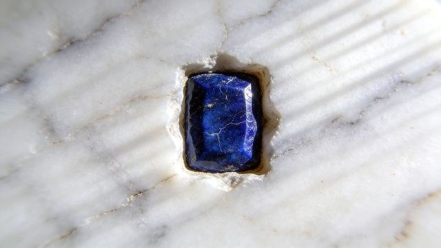 Deep indigo lapis inlay in white marble recess with diagonal shadow texture