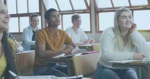 High school students studying and writing in sunlit classroom with desks taking notes