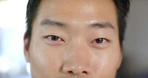 Close-up male headshot showing natural skin texture, neutral expression and direct gaze
