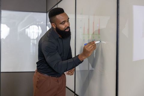 Business professional drawing bar charts in modern office