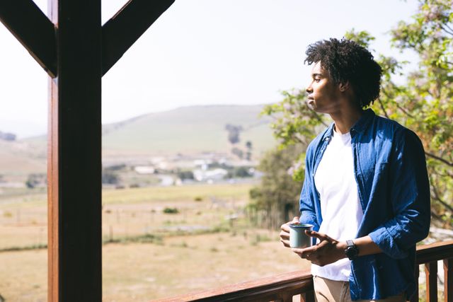 Man Enjoying Coffee on Balcony of Log Cabin in Nature - Download Free Stock Images Pikwizard.com