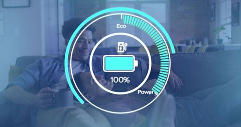 Young couple relaxing and cuddling on sofa with battery hud overlay showing full charge
