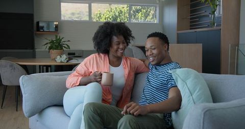 Couple Sharing Coffee and Conversation in Cozy Living Room