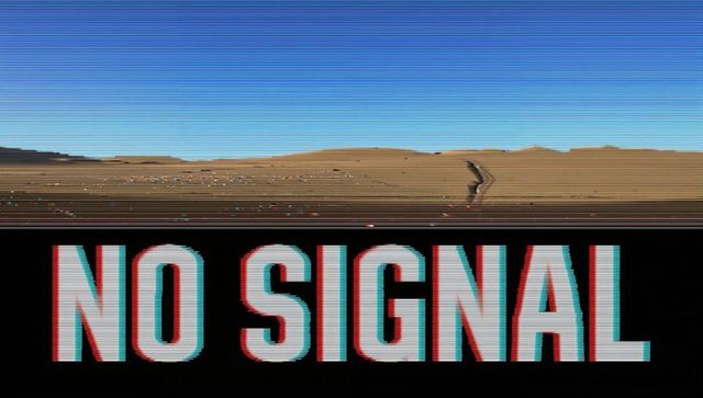No signal glitch over desert dunes with lone silhouette and scanline distortion
