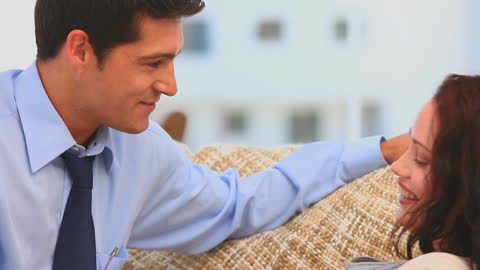 Expecting Couple Engaging in Warm Conversation on Cozy Sofa