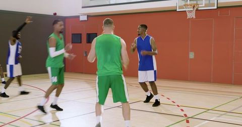 African american player driving to hoop as opponents celebrating missed shot