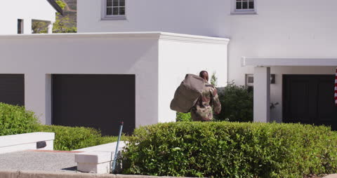 Returning Soldier with Bag Approaching Home