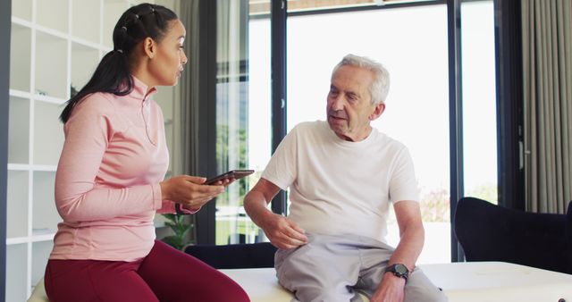 Image of biracial female physiotherapist examining caucasian senior man. seniors health and nursing home lifestyle concept digitally generated image.