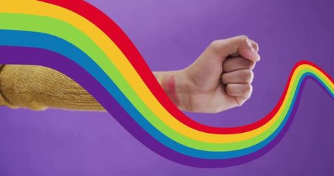 Clenching fist with rainbow ribbon signaling pride and resilience on purple background