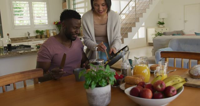 Happy diverse couple sitting at table and having breakfast - Download Free Stock Photos Pikwizard.com