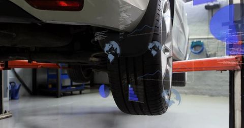 Car on lift showing rear wheel diagnostics and tire analytics with augmented reality
