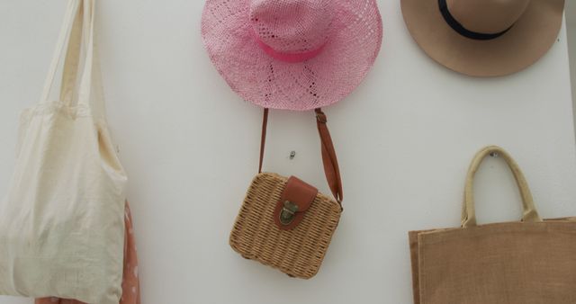 Various bags and hats hang on a white wall - Download Free Stock Photos Pikwizard.com